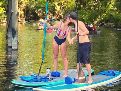 Kissing couple getting engaged on paddleboards
