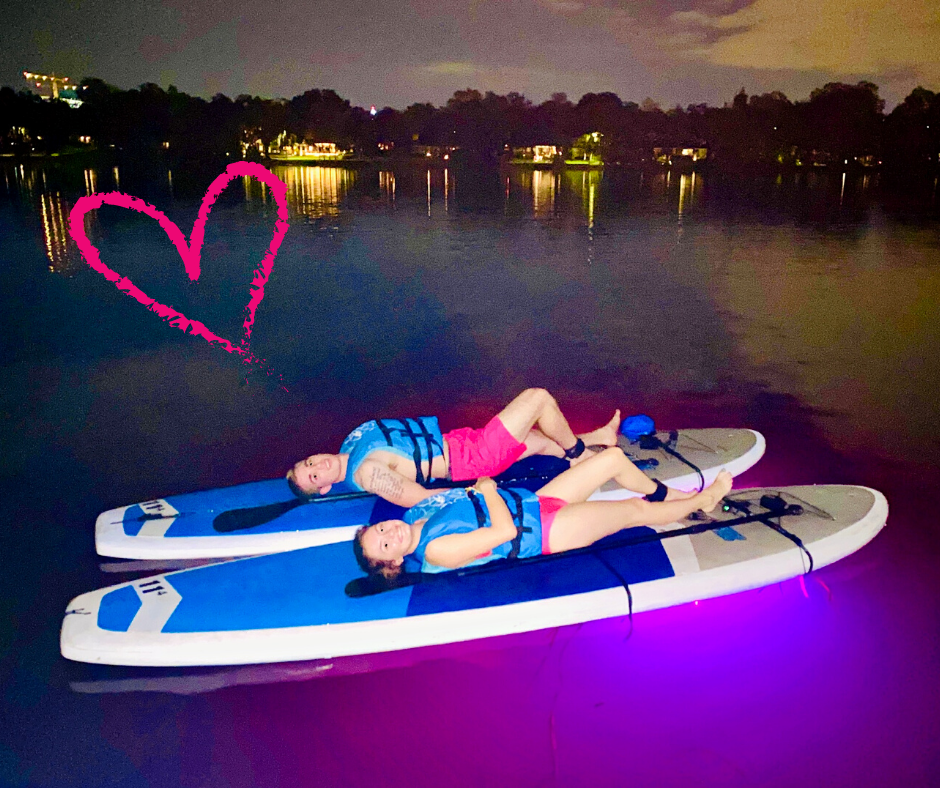 couple relaxing on paddleboards that glow in the dark