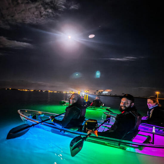 Couple in clear kayak glowing in the dark