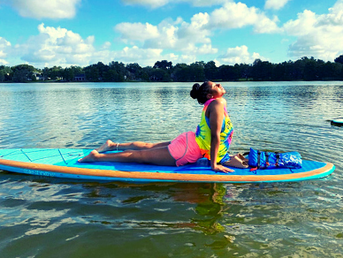 Doing yoga on a paddleboard on a sunny day