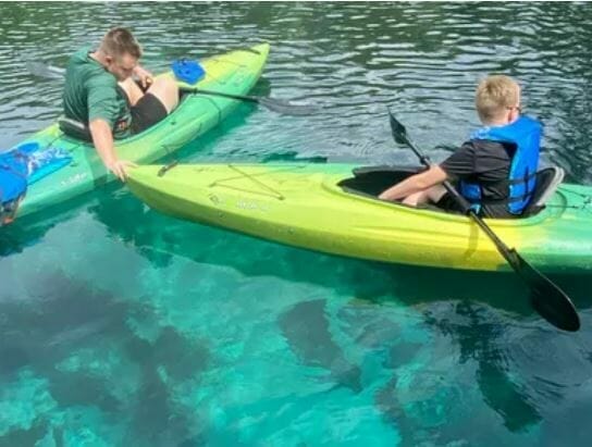 Kids kayaking in clear aqua water