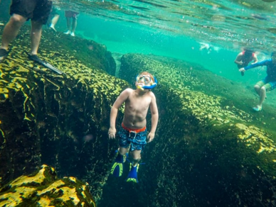 Kid snorkeling in underwater spring