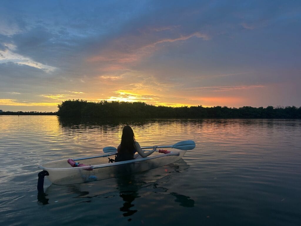 Clear kayak sunet tour in Orlando Florida with guests paddling at golden hour